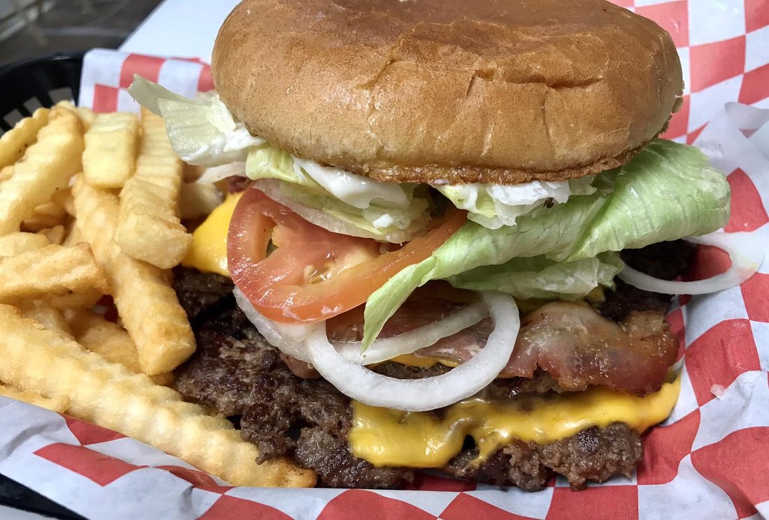 Hand pattied cheeseburger with waffle fries in a basket