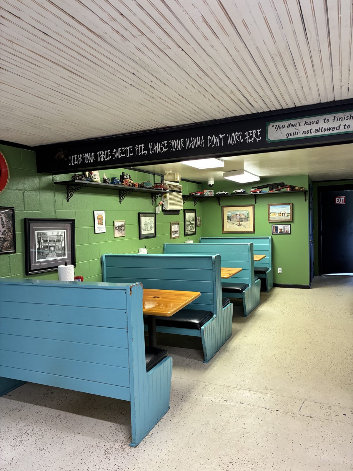 Dining room with teal booths and green walls